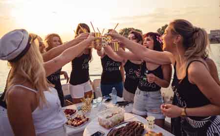 bachelorettes celebrating unique nautical theme aboard yacht in Montauk with gourment food and wine
